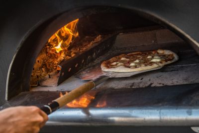 Four à pizza à bois disposé dans un jardin.